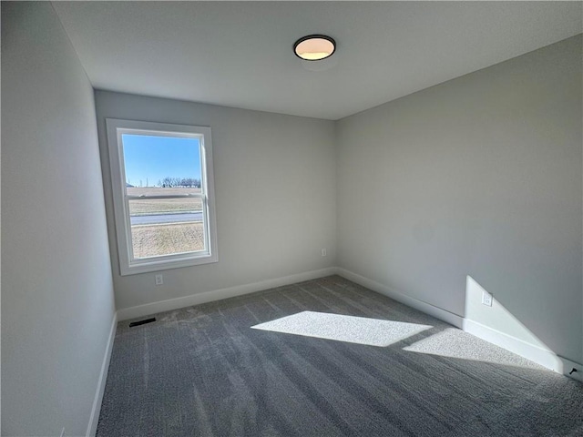 unfurnished room with dark colored carpet