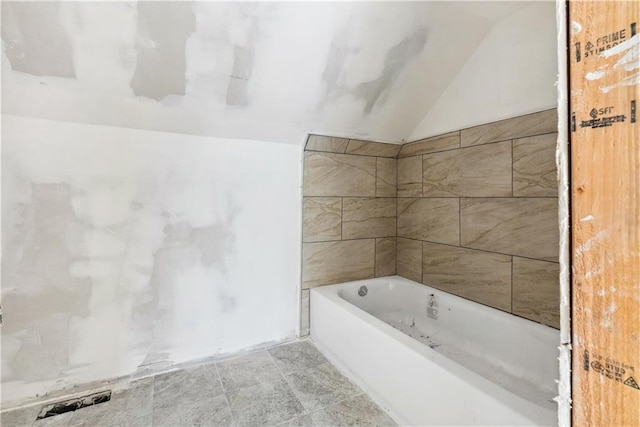 bathroom with a bathing tub and vaulted ceiling