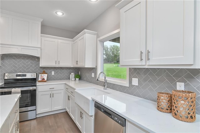 kitchen with dark wood-type flooring, sink, white cabinetry, stainless steel appliances, and decorative backsplash