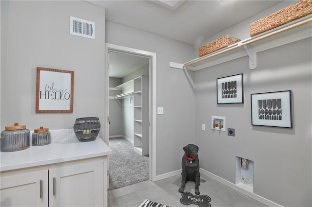 laundry area featuring electric dryer hookup, washer hookup, light colored carpet, and cabinets