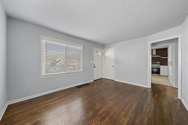 interior space featuring dark wood-style floors, visible vents, and baseboards