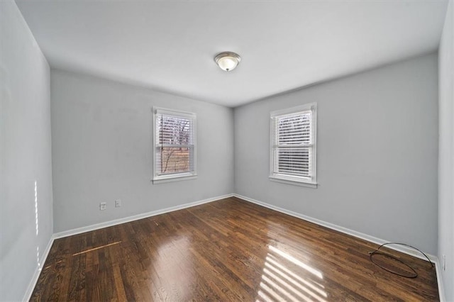 unfurnished room featuring baseboards and wood finished floors