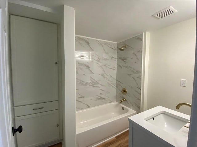 bathroom featuring vanity, tiled shower / bath combo, and hardwood / wood-style flooring