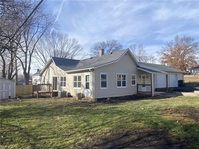 back of property featuring a garage, a yard, and central air condition unit