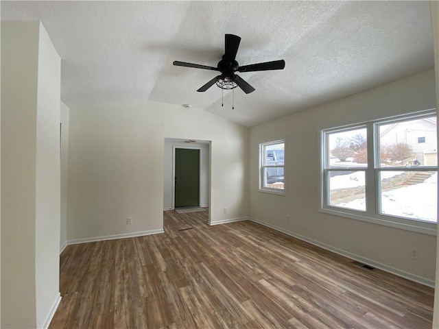 spare room with ceiling fan, a textured ceiling, vaulted ceiling, and wood-type flooring