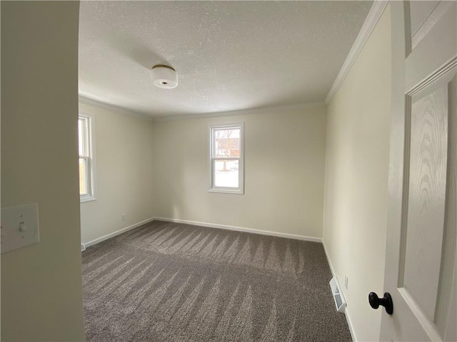 spare room featuring ornamental molding, a textured ceiling, and dark carpet