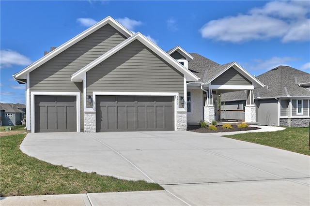 craftsman inspired home with driveway, stone siding, a garage, and a front lawn