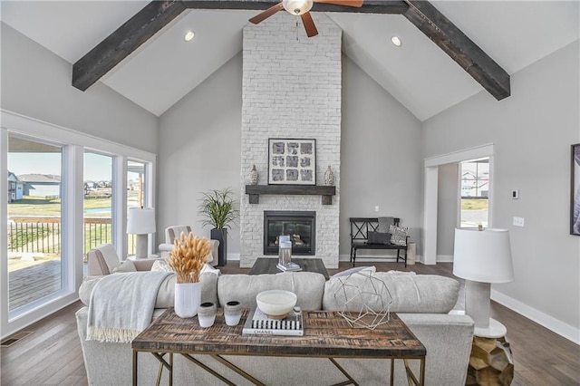 living area featuring dark wood-style floors, a fireplace, visible vents, and beam ceiling