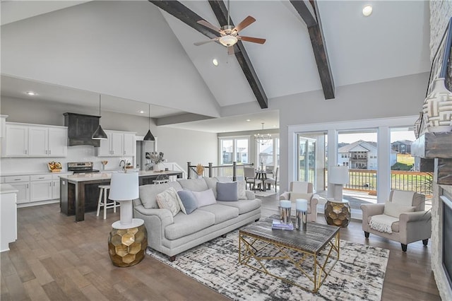 living area featuring dark wood-type flooring, beamed ceiling, ceiling fan with notable chandelier, high vaulted ceiling, and recessed lighting