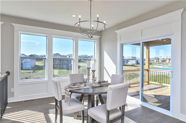 dining space featuring an inviting chandelier, baseboards, and dark wood finished floors