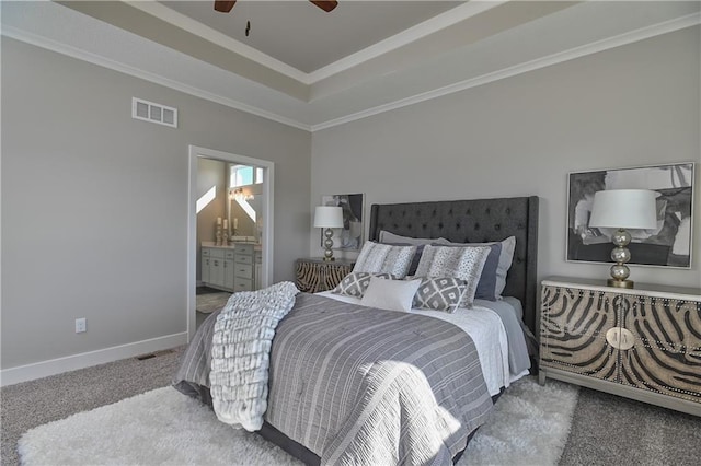 carpeted bedroom with baseboards, visible vents, ensuite bathroom, a tray ceiling, and crown molding