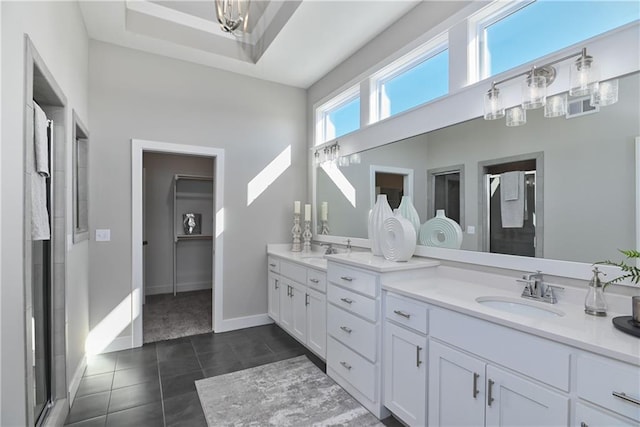 bathroom with double vanity, a stall shower, a sink, and tile patterned floors