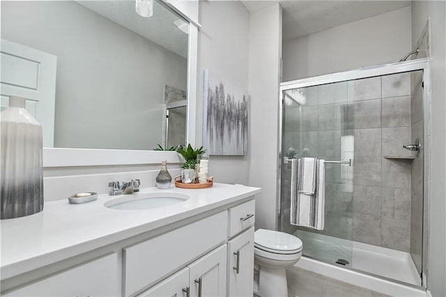 bathroom with toilet, a shower stall, and vanity