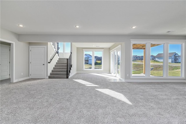 unfurnished living room featuring baseboards, visible vents, stairway, carpet flooring, and recessed lighting