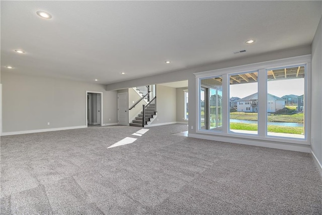 carpeted spare room featuring recessed lighting, visible vents, stairway, and baseboards