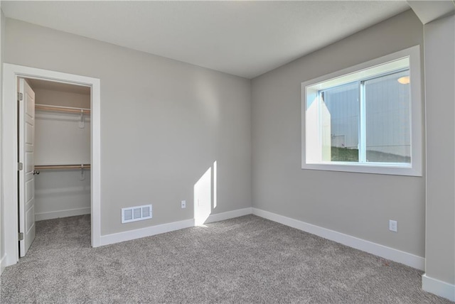 unfurnished bedroom with carpet floors, visible vents, and baseboards