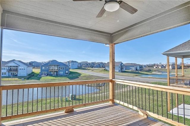 wooden terrace featuring a water view, a residential view, and a ceiling fan