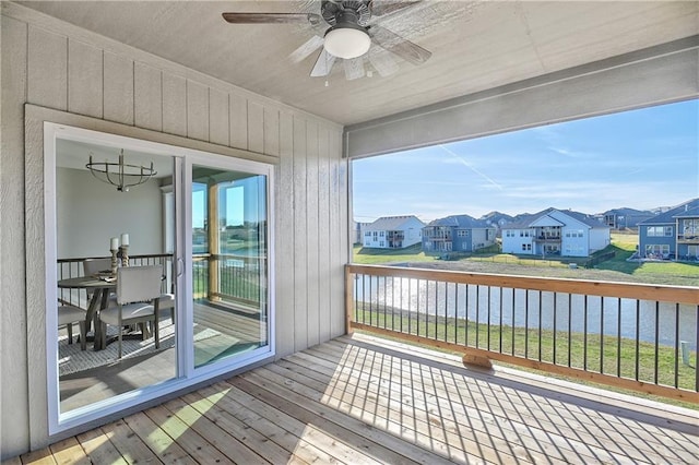 wooden deck featuring a water view, a residential view, and a ceiling fan