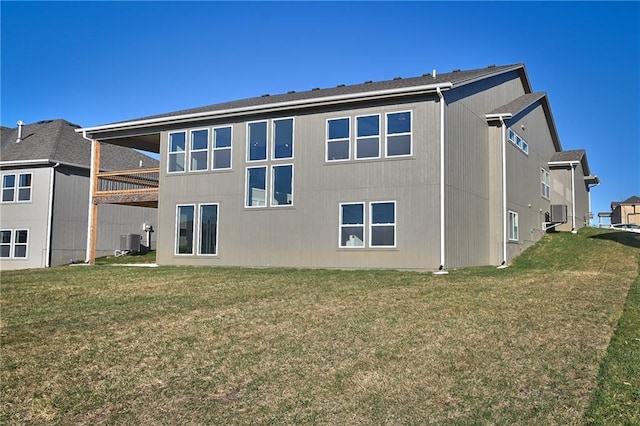 rear view of property with cooling unit and a yard