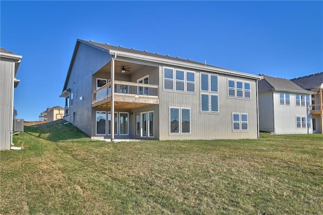 back of property featuring ceiling fan, a lawn, and a balcony