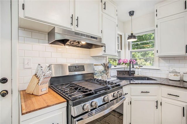kitchen featuring gas range, under cabinet range hood, a sink, and white cabinets