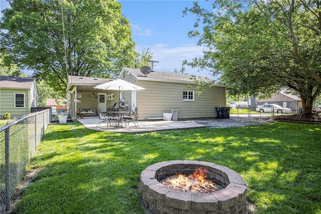 rear view of property featuring an outdoor fire pit and a patio area