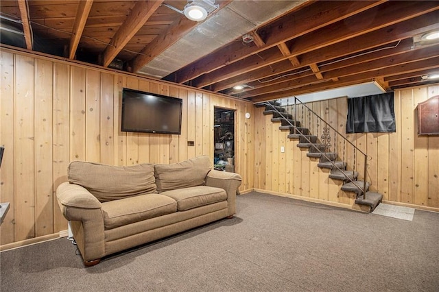 living room with stairway, baseboards, carpet floors, and wood walls