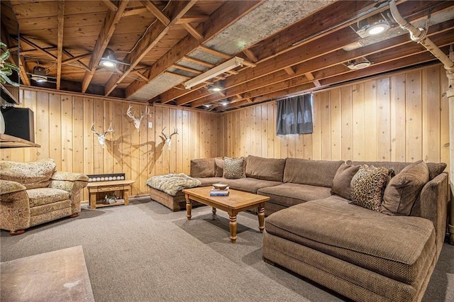 living area with carpet floors and wood walls
