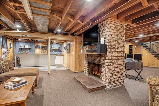carpeted living room featuring stairway, wood walls, and a fireplace