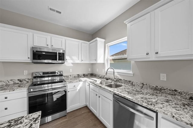 kitchen featuring dark hardwood / wood-style flooring, sink, stainless steel appliances, and white cabinets