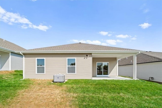 rear view of property featuring central AC, a patio area, and a lawn