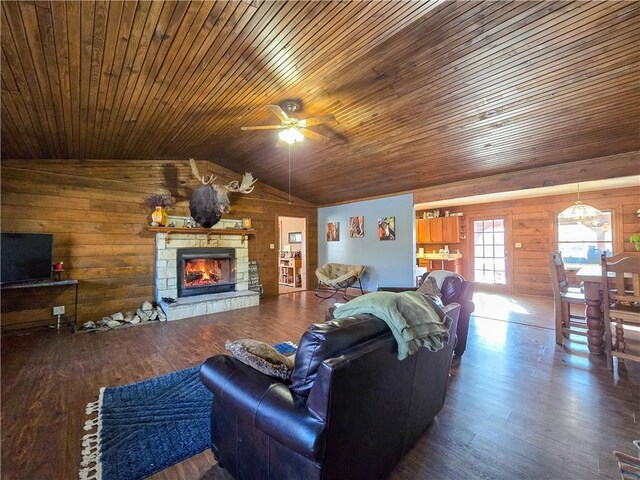 living room featuring lofted ceiling, a stone fireplace, hardwood / wood-style floors, and wood walls