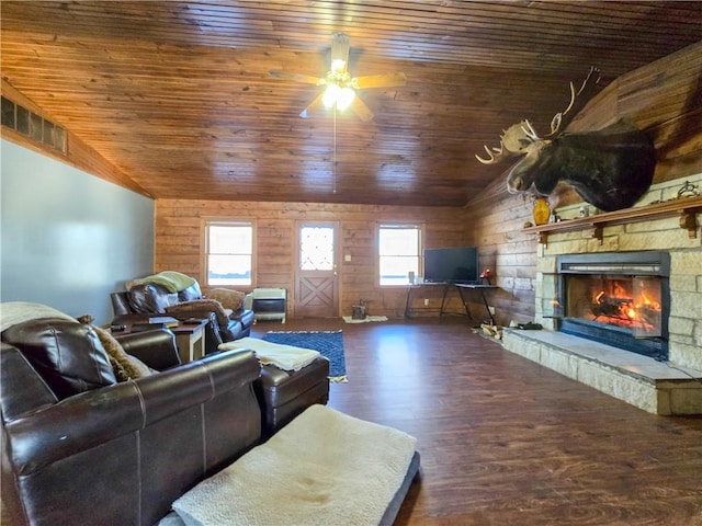 living room featuring a stone fireplace, dark wood-type flooring, a wealth of natural light, and lofted ceiling