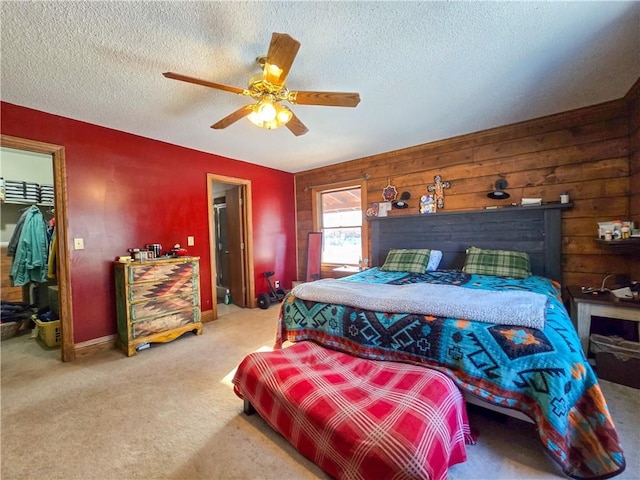 carpeted bedroom featuring ceiling fan, a spacious closet, a closet, and a textured ceiling