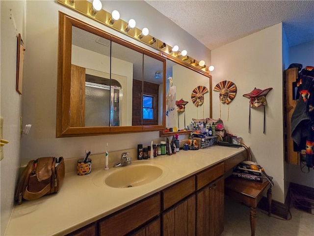 bathroom featuring vanity, an enclosed shower, and a textured ceiling