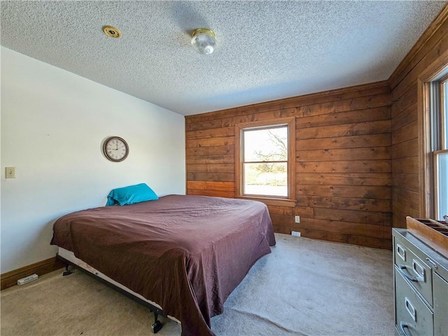 bedroom featuring carpet, a textured ceiling, and wood walls