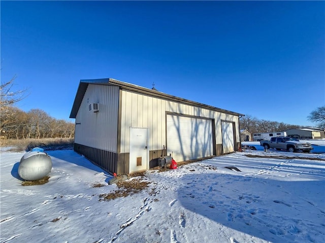 snow covered structure featuring a garage