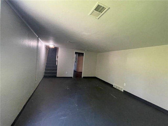 spare room featuring visible vents, concrete floors, baseboards, and stairs