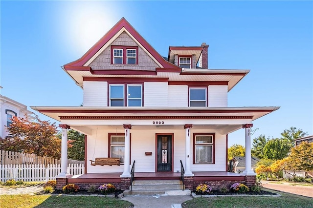 view of front of house featuring covered porch and a front lawn