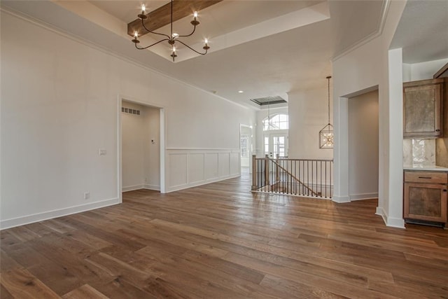 empty room featuring ornamental molding, visible vents, a chandelier, and dark wood finished floors