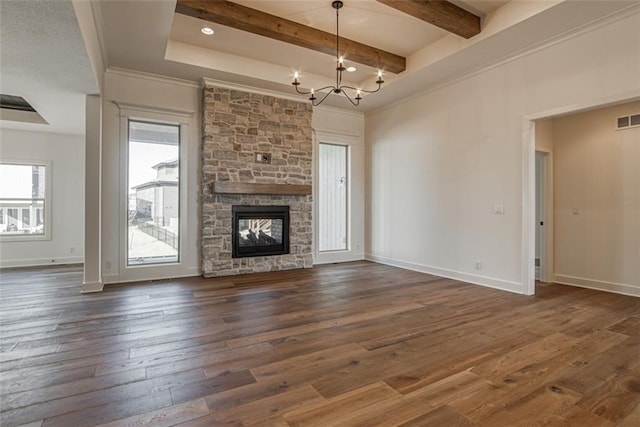 unfurnished living room with a notable chandelier, a fireplace, dark wood-type flooring, visible vents, and beamed ceiling