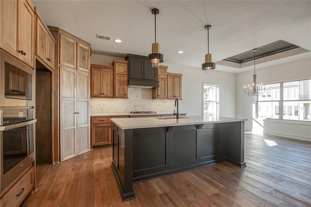 kitchen with visible vents, a sink, a chandelier, dark wood-style floors, and stainless steel appliances