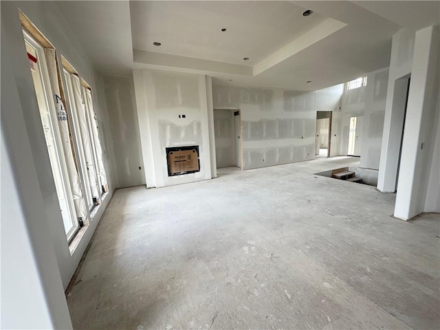17013 Parkhill St, Overland Park, KS 66221 - unfurnished living room with plenty of natural light, a fireplace, and a tray ceiling