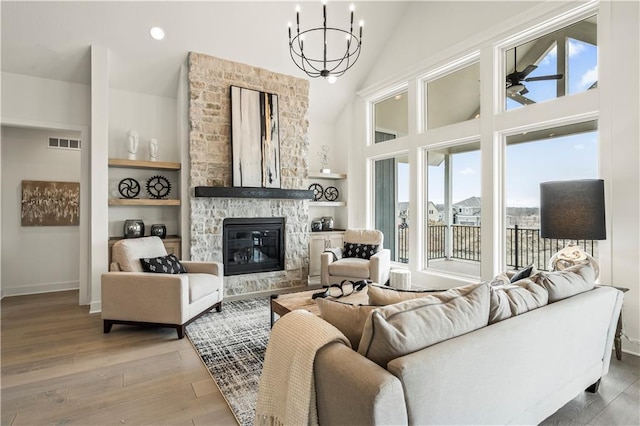 living area featuring light wood-type flooring, an inviting chandelier, visible vents, and a wealth of natural light