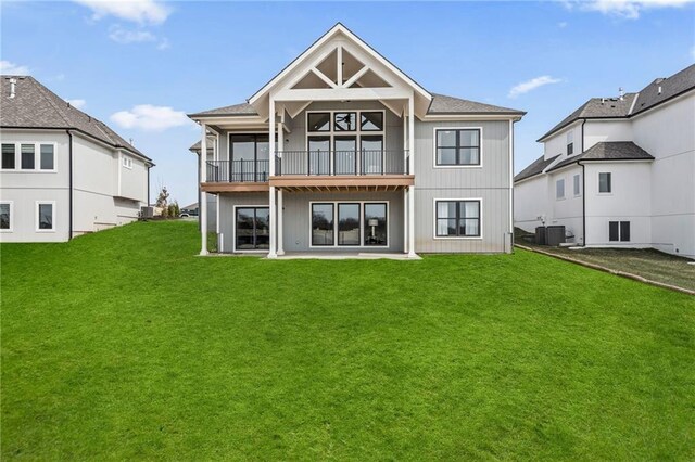 rear view of property with a yard and central AC