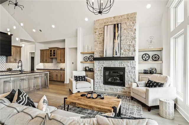 living area featuring high vaulted ceiling, light wood finished floors, and plenty of natural light