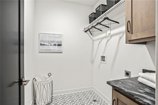 washroom featuring electric dryer hookup, washer hookup, baseboards, and cabinet space