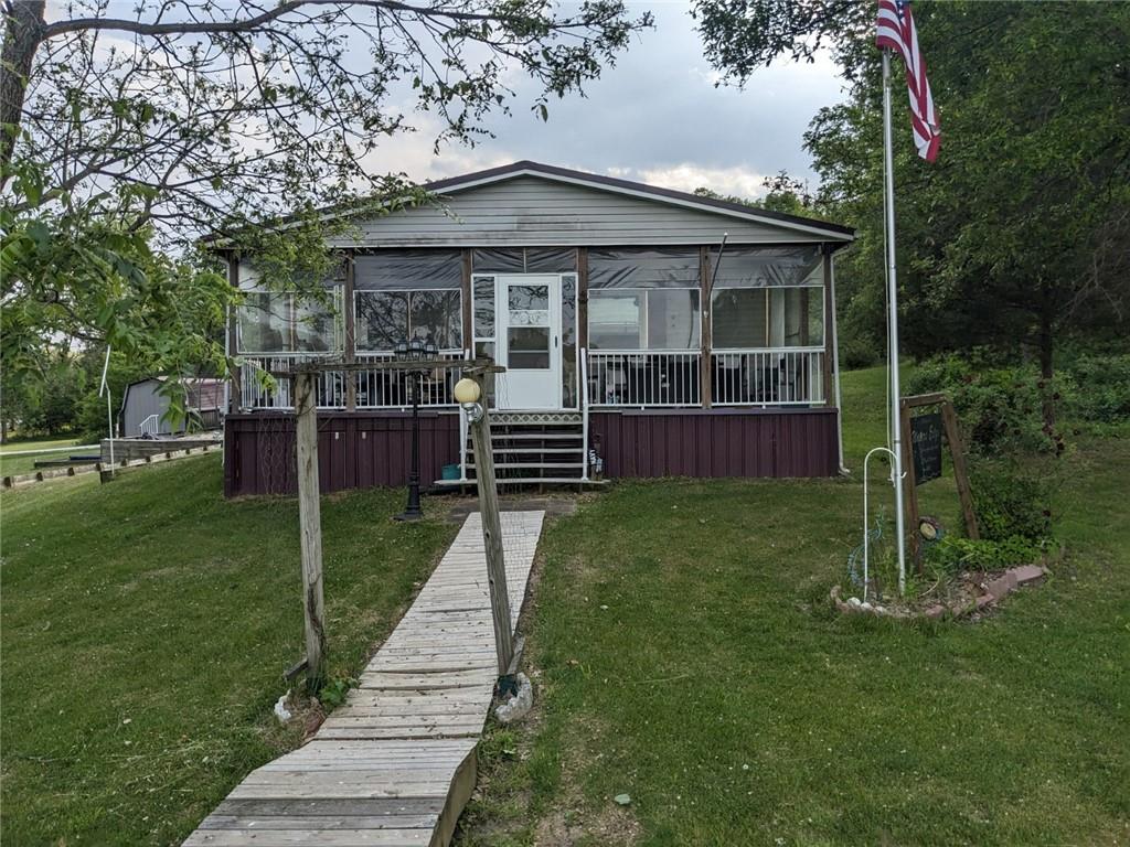 view of front of home featuring a sunroom and a front lawn