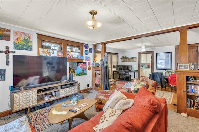 living room with light carpet, decorative columns, and baseboards