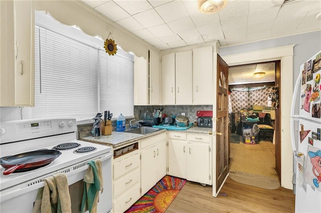 kitchen with light wood-style floors, white appliances, and a sink